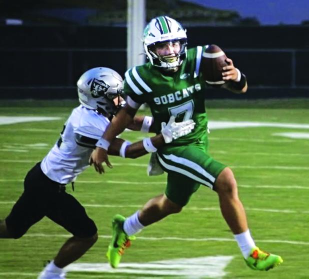 Bobcat quarterback Montana Brown tries to elude a Northwest tackler. (Photo by Rhett Manuel)
