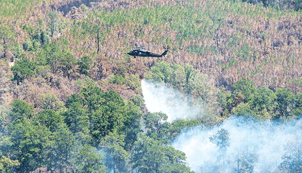 Aviators with the Louisiana National Guard and Alabama National Guard respond to wildfires in Vernon Parish on Aug. 31. Aviators use a bambi bucket to retrieve water and splash nearly 600 gallons of water at a time on the fires. (U.S. Army National Guard photo by Staff Sgt. Noshoba Davis)