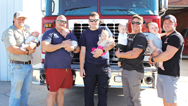 Five Eunice firefighters hold their newborns. The newborns range from 1 month-old to 9 months old. From left, are Firefighter/operator Ben Brown with daughter, Landry Brooks, 1 month old; Firefighter/operator Christian Walker with his 2-month-old son Stephen Russell; Firefighter/operator Blake Smith with his 3 month old daughter, Paisley Grace; Firefighter/operator Ryan Daville with his 8-month-old son, Ellis Scott; and Capt. Garrett Daville with 9-month-old son, Slade Noble. (Photo by Myra Miller)