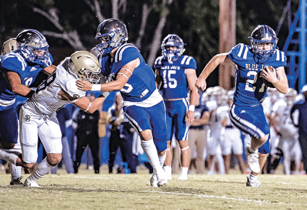 Henry Summerlin runs behinds a wall of St. Edmund blockers in the 57-7 win over Sacred Heart of Ville Platte on Friday. Summerlin is closing in on posting 1,000 yards rushing for the season. (Photo by Dwight Jodon)