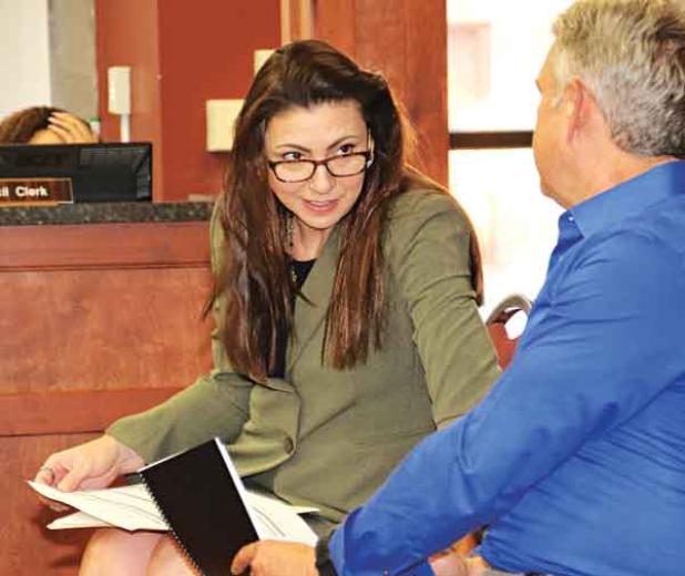 Sherri Zeringue McGovern, St. Landry Parish tax assesor, talks with Bill Rodier, parish economic development director, before Wednesday’s St. Landry Parish Council meeting in Opelousas. (Photo by Harlan Kirgan)