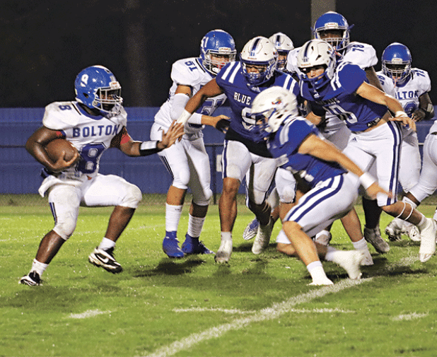 Blue Jay defenders focus on a Bolton runner in a 61-0 win. (Photo by Amy Myers)