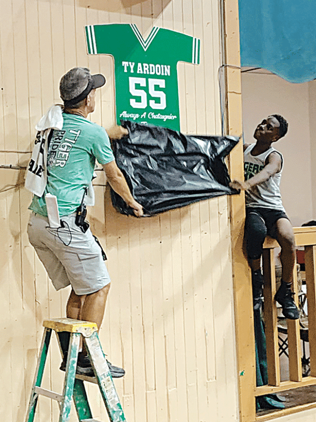 Chataignier Elementary basketball coach Duncan Johnston, left, and Zion Thomas unveil Ty Ardoin’s retired number 55 jersey. (Ville Platte Gazette photo by Rhett Manuel)