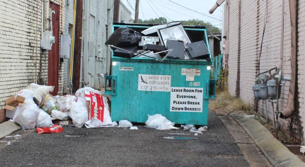 Donna Baltakis pointed out this overflowing trash bin in an alley on 2nd Street Wednesday morning. Baltakis is director of Keep Eunice Beautiful. 