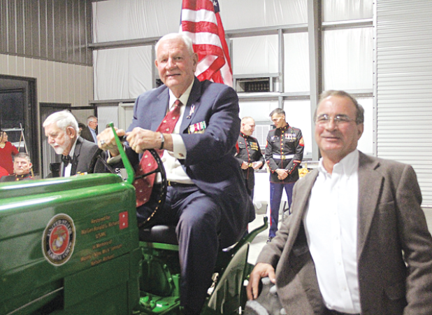 Maj. Gen. Ronald J. Richard sits atop his grandfather’s tractor that was restored by Tom Klumpp, right, owner of Klumpp Equipment on the Basile Eunice Highway. Klumpp was one of the hosts for a Marine Corps Birthday Ball held Nov. 10 to celebrate the 246th birthday of the United States Marine Corps. (Ville Platte Gazette photo by Tony Marks)