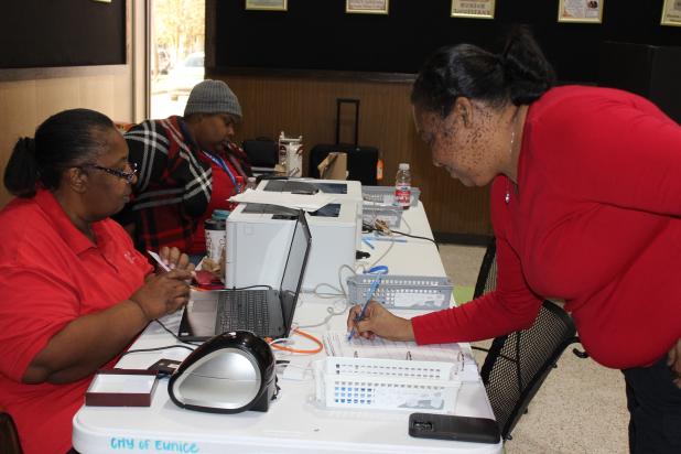 Dorothy LaBrie of Opelousas signs her name with Commissioner Cynthia Martin on Nov 29 during early voting at Eunice City Hall. Seated next to Martin is Commissioner Alexis Gallien. (Photo by Myra Miller)