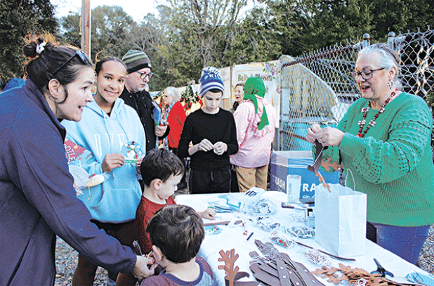 Angela Huckaby with CDA Court 208 demonstrates how to craft reindeer antlers at the Eunice Community Garden Christmas Festival Thursday. From left are Gabriel Daire, Branson Daire, Gina Daire, Jayla Mickens, Michael Laird and Jax Laird. Huckaby also had crafts of Christmas ornaments.Turn to Page 10 for more photos from the festival. (Photo by Myra Miller)