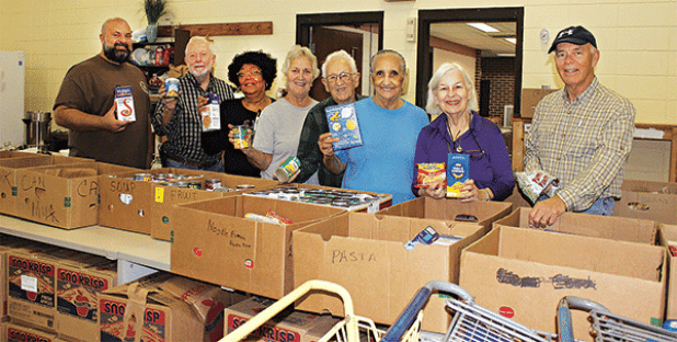 The Eunice Food Bank annual Food Drive was held Tuesday. Many volunteers were on hand ‘giving a hand.’ The early morning volunteers at the food bank included, the Rev. Heath McWilliams, left, David Guillory, Mary Ann Guillory, director; Jean Vige, Harry Reed, Tina Thomas, Darilyn Ardoin and Ron Driggs. (Photos by Myra Miller)