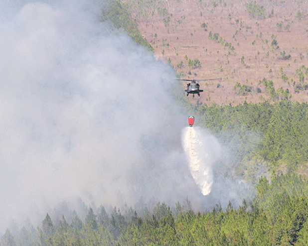 Louisiana National Guard aviators conduct water dropping missions to aid the Louisiana Department of Agriculture and Forestry, Louisiana State Fire Marshal office and local officials in combating the wildfires in Beauregard Parish near Deridder, Louisiana, Aug. 23, 2023.  (U.S. Army National Guard photo by Sgt. 1st Class Scott D. Longstreet)