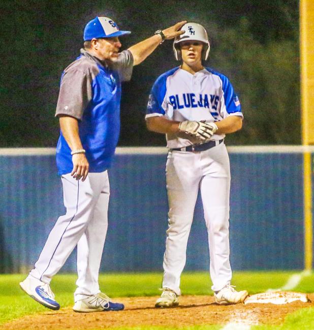 St. Edmund head coach Barry Manuel congratulates Clay Aguillard when he reached third base. 