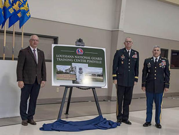 Louisiana Governor John Bel Edwards, Louisiana National Guard Adjutant General Maj. Gen. Keith Waddell and Louisiana National Guard Senior Enlisted Leader Command Sgt. Maj. Clifford Ockman unveil the Louisiana National Guard Training Center Pineville signifying the installation’s redesignation from Camp Beauregard to LANG TCP during a redesignation ceremony at the Dabadie Gym in Pineville, Louisiana, Oct. 18. (U.S. Army National Guard photo by Staff Sgt. Noshoba Davis)  