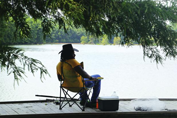 Temperatures were in the upper 80s on Thursday afternoon, but this shady spot on the edge of the Eunice City Lake felt comfortable. Tyler Fonville, of Eunice, was fishing there and said the fish were not biting. However, the turtles were biting and he had kept a few of them. (Photo by Harlan Kirgan) 