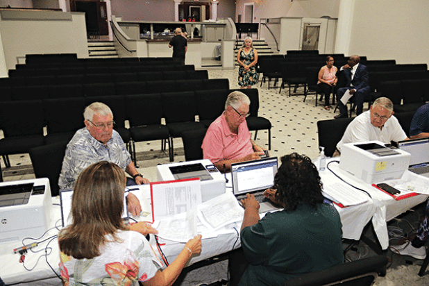Candidates for St. Landry Parish Council seats, from left, are Wayne Ardoin, District 9, Alvin Stelly, District 7, and Harold Taylor, District 5. They were the first to take seats to give their information to qualify for the October election. Qualifying is held at the Delta Grand Theater in Opelousas and ends at 4:30 p.m. Thursday. (Photo by Harlan Kirgan)