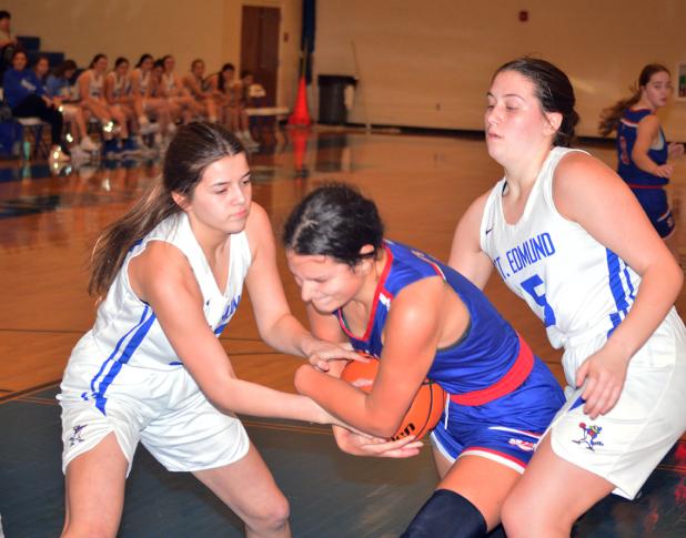 St. Edmund’s Jillian DeVillier and Alice Brown battle South Cameron’s  Reagan Veronie for a jump ball. (Photo by Tom Dodge)
