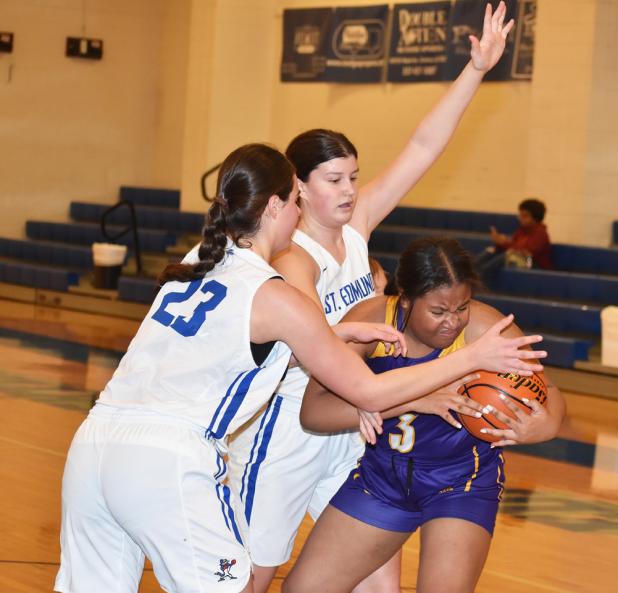 St. Edmund’s Aubrie LeJeune and Kennedy Dubroc surround Opelousas Catholic’s London Francis. 