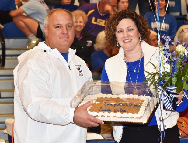 St. Edmund athletic director James Shiver presents head girls basketball coach Erica Zaunbrecher a cake, flowers and balloons after her 19th win – a season high record for the Lady Jays coach. 