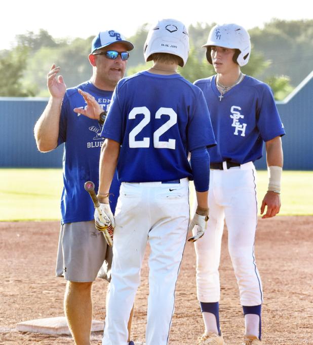 St. Edmud head coach Nick Trosclair talks with two Blue Jay players.