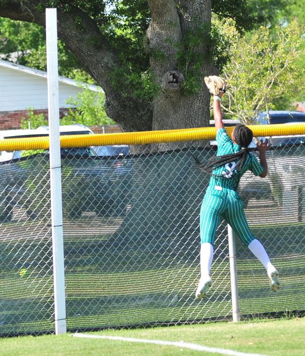 Eunice High right fielder Harmony Jason leaps as a North DeSoto home run clears the fence.
