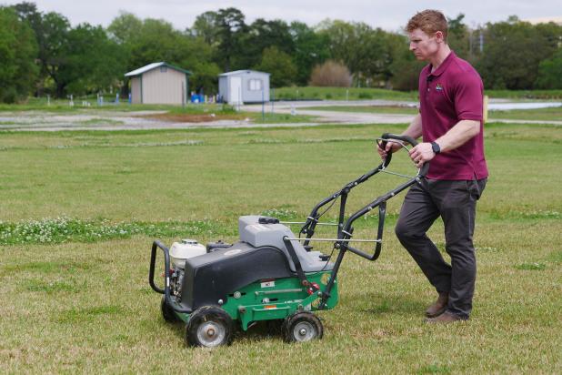 Eric DeBoer, an assistant professor of turfgrass management with the LSU AgCenter, demonstrates using an aerator. (Photo by Olivia McClure/LSU AgCenter)