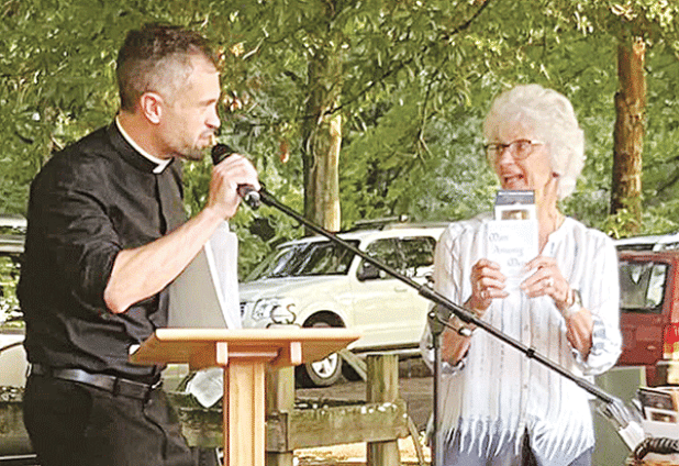 Carrol LaFleur, right, talks about books on the life of the Rev. Verbis LaFleur, who was declared a servant of God by the Diocese of Lafayette. On the left is the Rev. Travis Abadie, pastor of St. Francis Regis Catholic Church of Arnaudville. (Photo courtesy of St. Bernard Catholic Church)