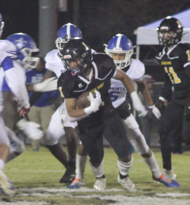 A Church Point runner faces a wall of West Feliciana players. 