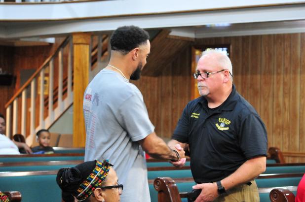 Chief Kyle LeBouef and Paul DeRousselle shaking hands after receiving the award
