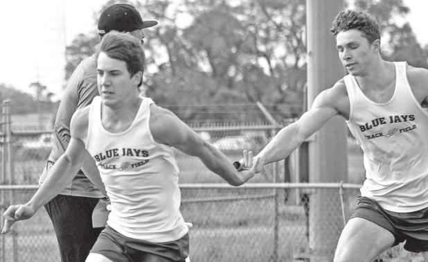 St. Edmund’s Luke Trahan takes the baton from Easten Coleman. (Photo by Tom Dodge)