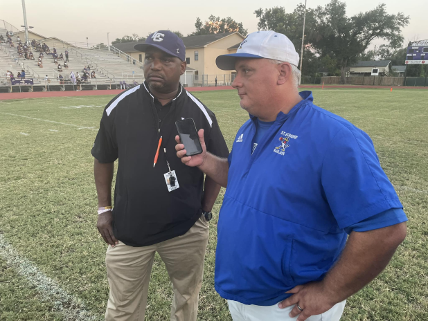 St. Edmund head coach James Shiver holds his phone as he and LaGrange head coach Maricco Wilson talk with a LHSOA official. (Photo courtesy of Barry Spears)