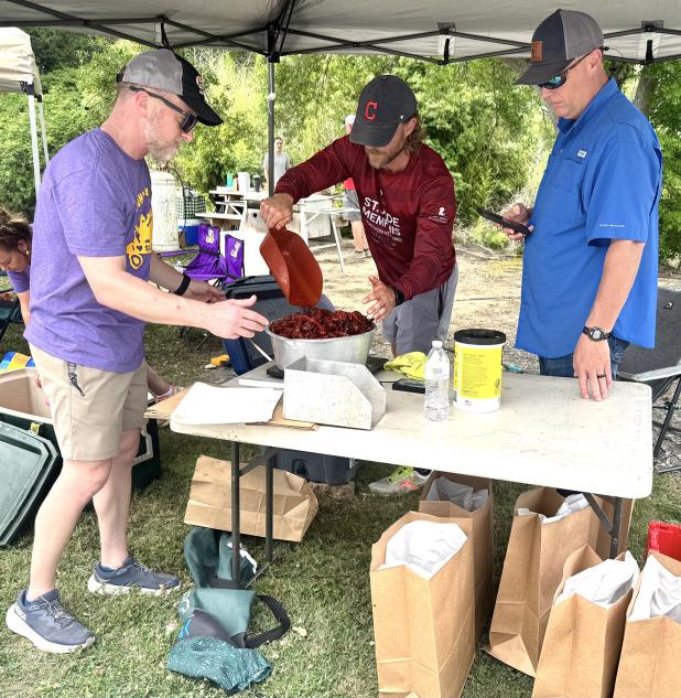 Crawfish for a Cure Organizer David Reed serves a customer with the help of charity volunteers. (Photo by Rebecca Chaisson)
