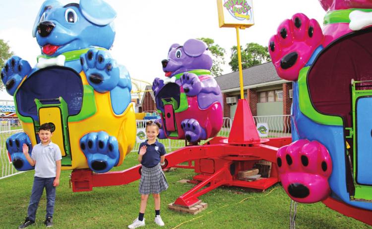 St. Edmund Elementary first graders Charles Patrick Cunningham and Harleigh Credeur are looking forward to this weekend for the St. Edmund Spring Fair. Their teacher is Michelle Newsom. The Puppy Roll is one of the many fair rides on the grounds behind the elementary school. (Photos by Myra Miller)