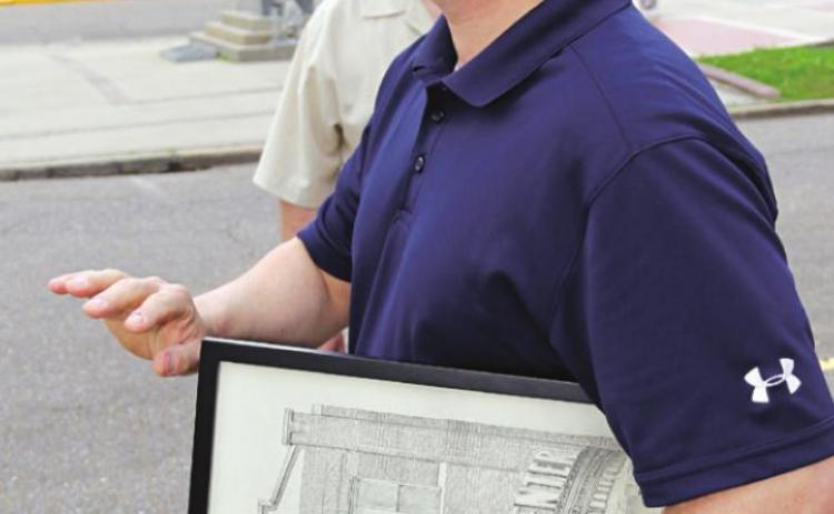 U.S. Rep. Mike Johnson is shown in Eunice on Friday holding artwork of the Liberty Theater presented to him by Zach Soileau, of Eunice. (Photo by Harlan Kirgan)