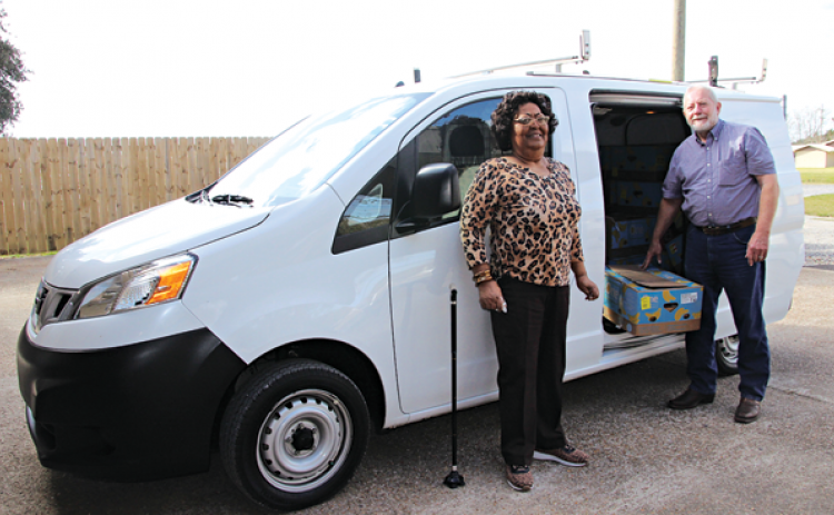 Mary Ann Guillory, Food Bank director, and David Guillory with a new van from Bob Giles. (Photo by Myra Miller)