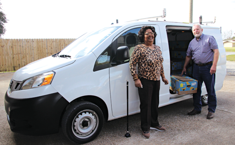 Mary Ann Guillory, Food Bank director, and David Guillory with a new van from Bob Giles. (Photo by Myra Miller)