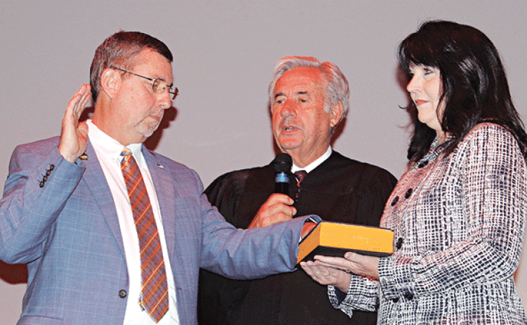 St. Landry Parish President Jessie Bellard, left, recites his oath delivered by Louisiana Associate Supreme Court Judge James Genovese and Bellard’s wife, Melissa, holds a bible.