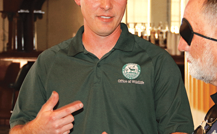 Dustin Champagne, a wildlife biologist with the Louisiana Department of Wildlife and Fisheries, speaks with Eunice Rotarian Randall Vige at Wednesday’s meeting. (Photo by Harlan Kirgan)