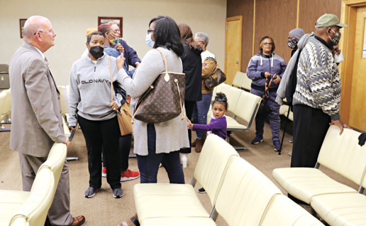 Eunice Police Chief Randy Fontenot, let, visited with people after Tuesday’s city meeting. (Photo by Harlan Kirgan)