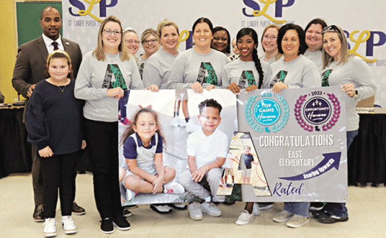 East Elementary in Eunice was recognized as an A-rated school in the state accountability scoring for 2023. A banner was presented to the school at Thursday’s St. Landry Parish School Board meeting. At left is Superintendent Milton Batiste. Holding the banner at left is Principal Gina LaGrange. Others in the photos are faculty members and their children. (Photos by Harlan Kirgan)