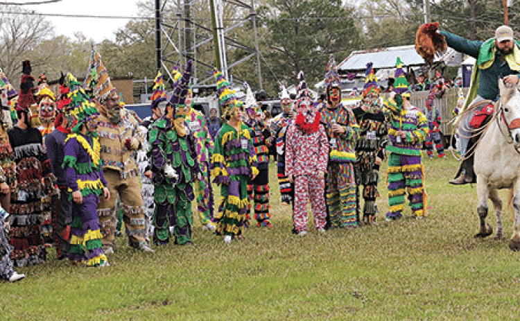 A capitaine holds a chicken aloft as runners are about to give chase in Le Vieux Mardi Gras De Cajuns de Eunice in 2023. (Photo by Harlan Kirgan)