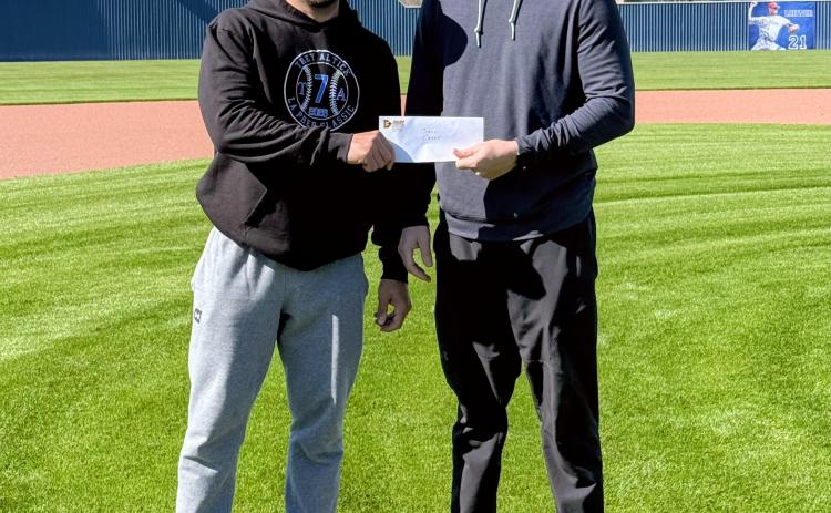 St. Edmund head coach Casey Charlie, left, and Stefan Frey of Frey Development stand at the Blue Jay Field as Frey Development announces its sponsorship of the upcoming Frey Development Prep Classic, set for Feb. 26–28.