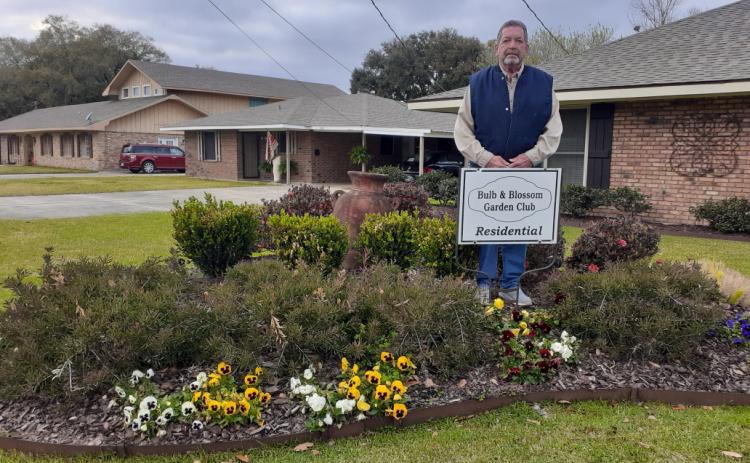 Keith Aucoin is pictured with the marker of Residential Garden of the Month presented by the Bulb & Blossom Garden Club