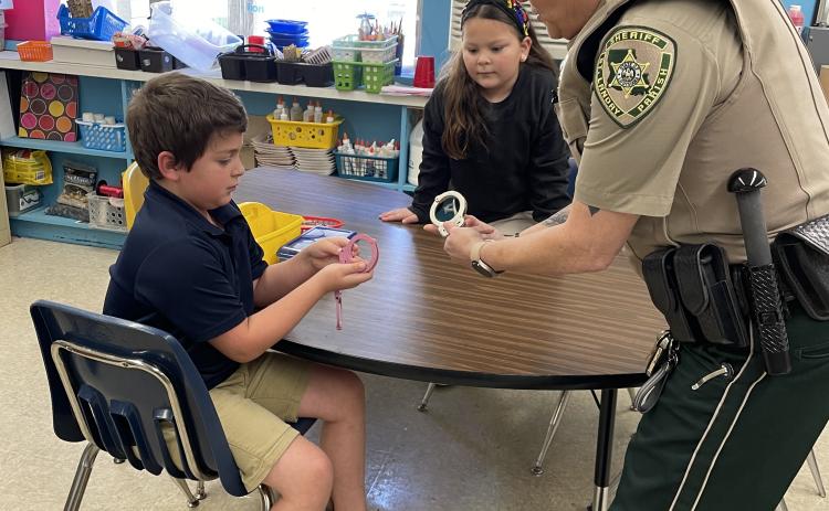Lt. Regina Rinaldi, with the St Landry Parish Sheriff’s Department DARE program, demonstrates the use of her hand cuffs after the weekly DARE lesson at East Elementary.