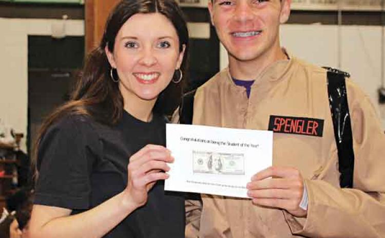 Jade Fontenot, a teacher at Eunice High, presents a $100 cash reward to Eunice High School’s Student of the Year Philippe Soileau during the school’s Renaissance Pep Rally. (Photo by Myra Miller)