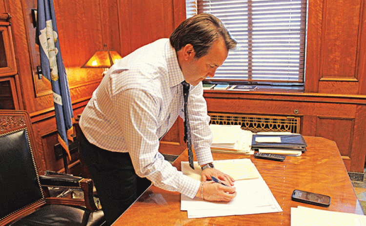 Speaker of the House of Representatives and Rep. Phillip DeVillier signs bills that were passed in the House on March 18. (Photo by Claudette Olivier/Crowley Post-Signal)