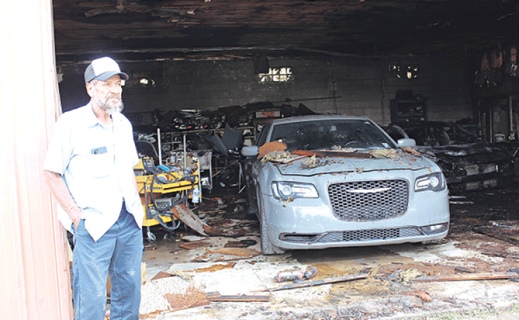 Kurn Semien, 70, stands by the fire-damaged paint and body shop he owns at 601 E. Laurel Ave., Eunice, on Tuesday. Fire damaged the shop on Monday. (Photo by Myra Miller)