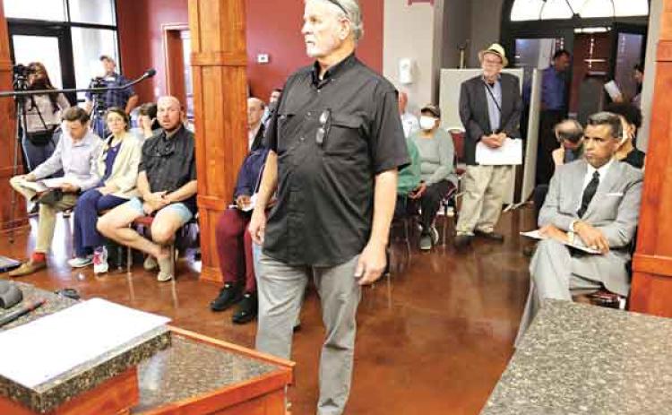 Opelousas attorney Robert Voitier Jr. opposed the removal of a Confederate monument on the St. Landry Parish courthouse grounds during a Parish Council meeting Wednesday in Opelousas. Seated at right is former Parish District Attorney Charles Cravins who argued for the monument’s removal. Standing in the rear is Don Leger, of Opelousas, who also supported removal of the monument. The Parish Council voted to remove to monument. (Photo by Harlan Kirgan)