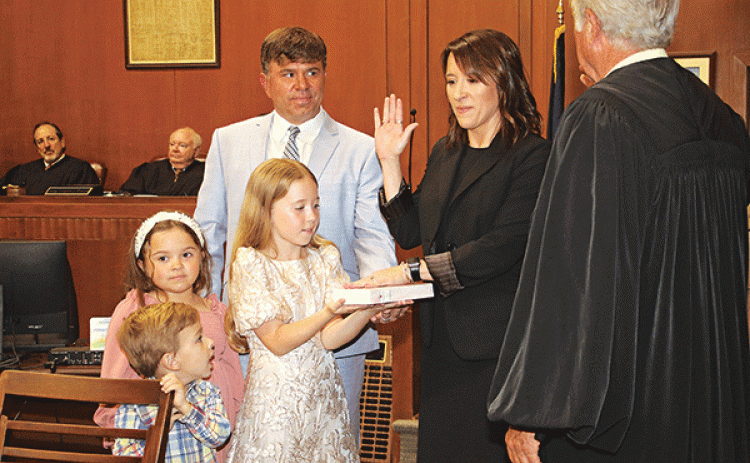 Laura Rougeau Garcille recites her oath of office delivered by State Supreme Court Judge James Genovese on Wednesday in the St. Landry Parish Courthouse. With her is her husband, Brett, and children, Emmy, 9, holding a Bible, Riley, 7, and John Roth, 4. Seated in the background are District Judges Gregory Doucet and James Dotherty. (Photos by Harlan Kirgan)
