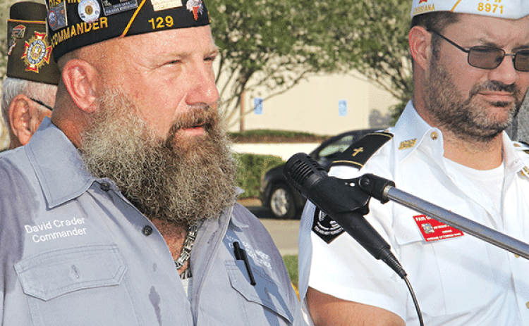 American Legion Post 129 Commander David Crader speaks at Monday’s ceremony.  At right is VFW Post  8971 member Paul Ganucheau. (Photo by Harlan Kirgan)