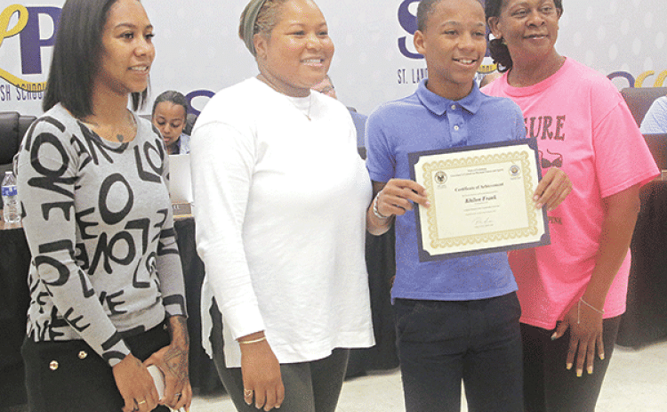Khilon Frank, a Central Middle School student, holds a certificate for his performance in the Louisiana Elementary State Championship Fitness Meet Governor’s Games at the May 1 St. Landry Parish School Board meeting. Frank placed third in the state games in standing long jump. From left, are Kierra Poullard, his mother; Tamika Zachary, health and physical education teacher at Creswell Middle School in Opelousas, Frank; and Abigail Semien, Frank’s grandmother. Zachary organized the parish games at Northwest