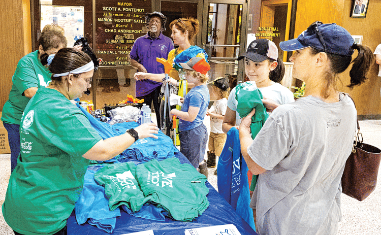 Volunteers pick up T-shirts and cleaning supplies on April 22 at the Eunice Municipal Complex lobby. (Photoo by David Simpson)