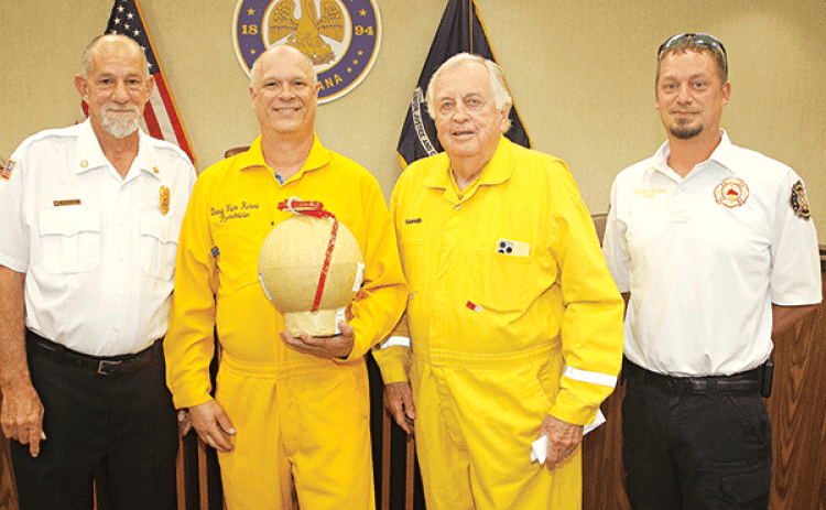 Fireworks were discussed at Tuesday’s Eunice Board of Aldermen’s meeting. Former Mayor Kenneth Peart, third from left, said he is stepping back from his role as the lead in staging the Fourth of July show at the Recreation Complex. From left, are Acadia Parish Fire District 4 Chief Harral “New York” Johnson; Donald Richard, who is taking the lead for the fireworks show and holding an aerial shell; Peart; and Eunice Fire Chief Chaise Brown. (Photo by Harlan Kirgan)